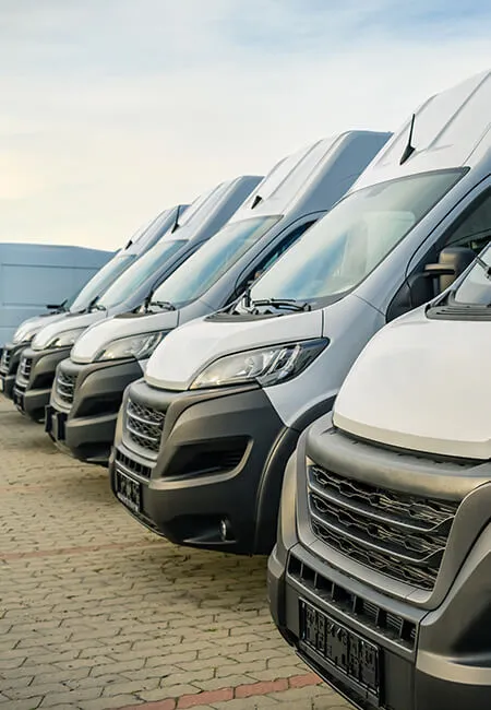 Fleet of white delivery vans parked in a row.