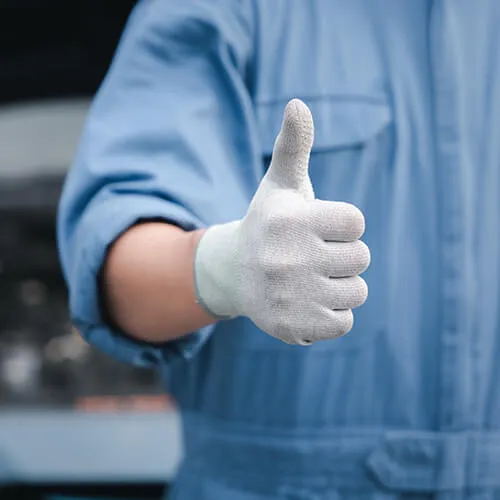 Mechanic giving thumbs up in blue uniform