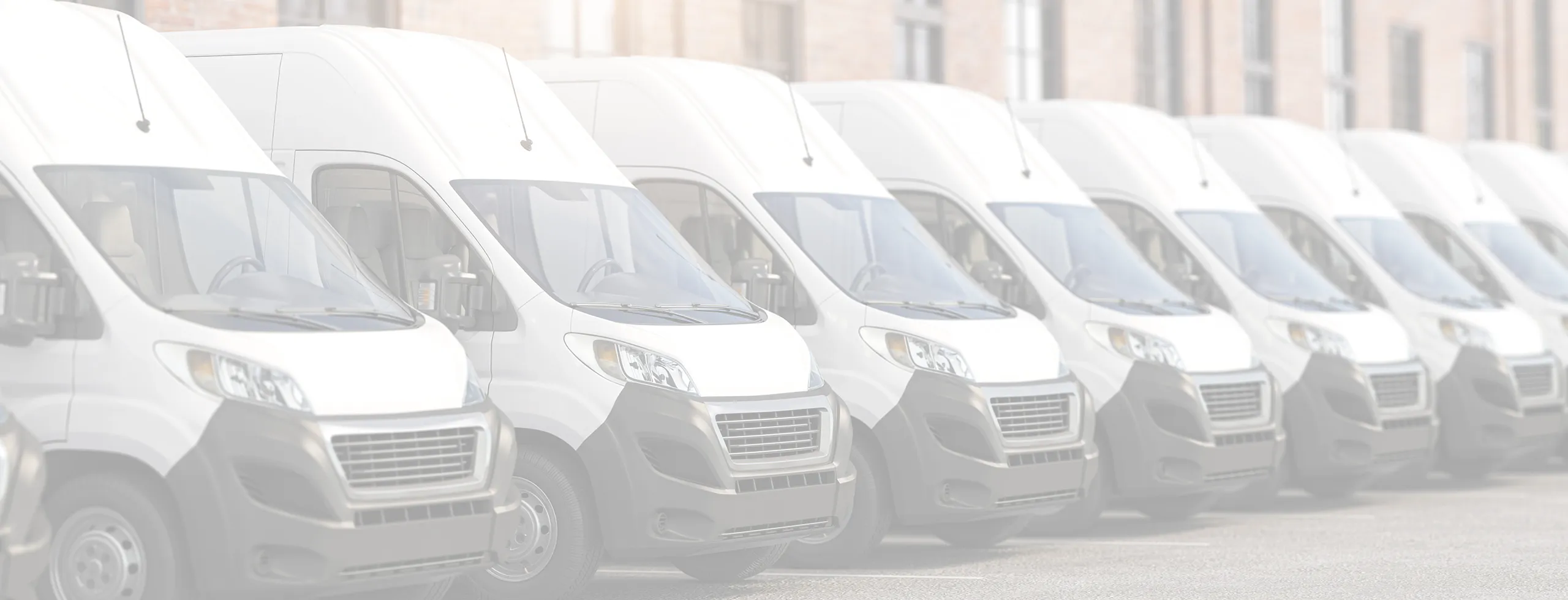 Fleet of parked white delivery vans